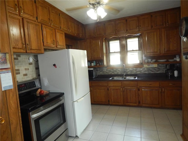 kitchen featuring electric range, a sink, brown cabinetry, and tasteful backsplash