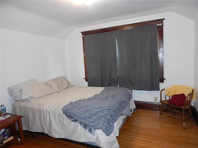 bedroom featuring vaulted ceiling and wood finished floors