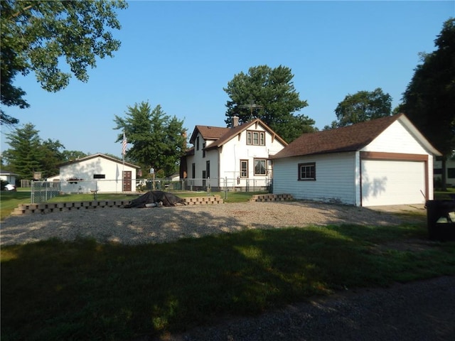 back of house with a garage, a chimney, and an outdoor structure