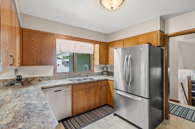2807 Edgewood Dr N, Fargo, ND 58102 - kitchen featuring appliances with stainless steel finishes, a sink, brown cabinets, and a textured ceiling