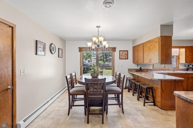 2807 Edgewood Dr N, Fargo, ND 58102 - dining area with baseboard heating, a chandelier, and a textured ceiling