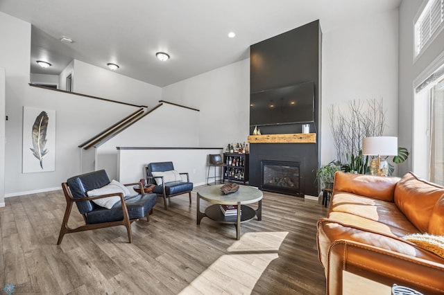 977 Ashley Dr W, West Fargo, ND 58078 - living room with wood finished floors, baseboards, a glass covered fireplace, and a high ceiling