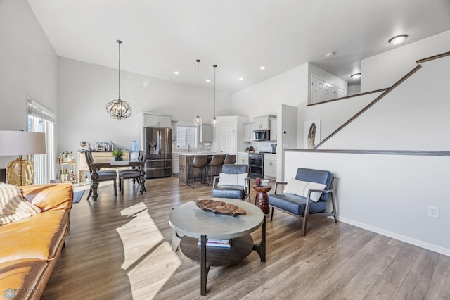 977 Ashley Dr W, West Fargo, ND 58078 - living area featuring high vaulted ceiling, wood finished floors, recessed lighting, baseboards, and a chandelier