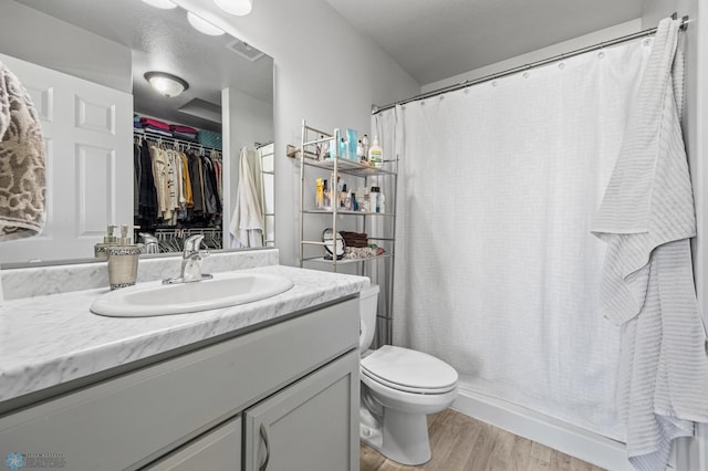 977 Ashley Dr W, West Fargo, ND 58078 - full bathroom featuring wood finished floors, vanity, toilet, and curtained shower