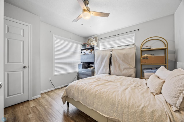977 Ashley Dr W, West Fargo, ND 58078 - bedroom featuring wood finished floors, baseboards, and a ceiling fan