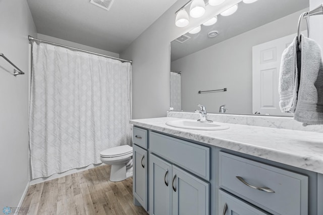 977 Ashley Dr W, West Fargo, ND 58078 - bathroom with vanity, wood finished floors, toilet, and a shower with curtain