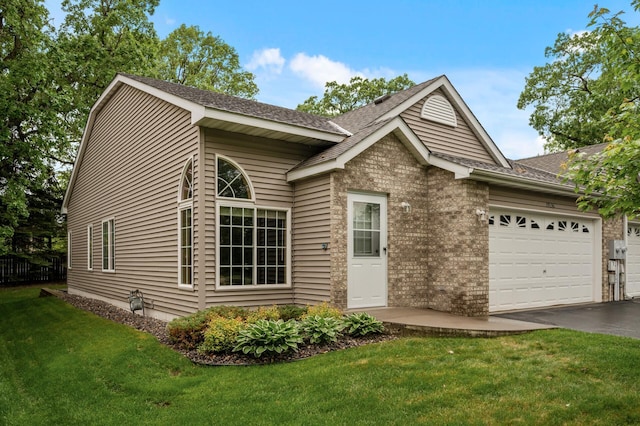 19136 Concord Ct NW, Elk River, MN 55330 - view of front of home featuring a garage, a shingled roof, a front lawn, driveway, and brick siding