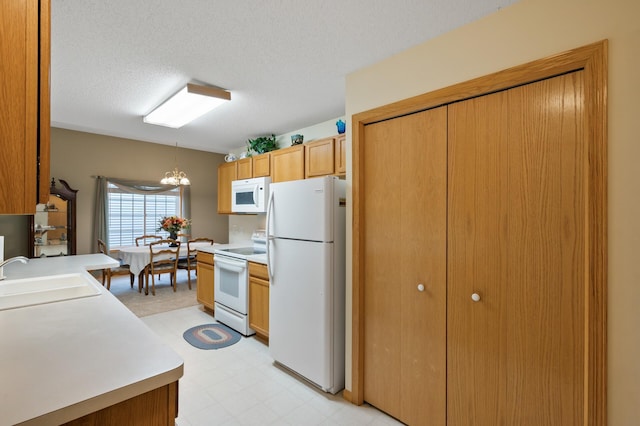 19136 Concord Ct NW, Elk River, MN 55330 - kitchen featuring white appliances, a sink, light flooring, a chandelier, and light countertops