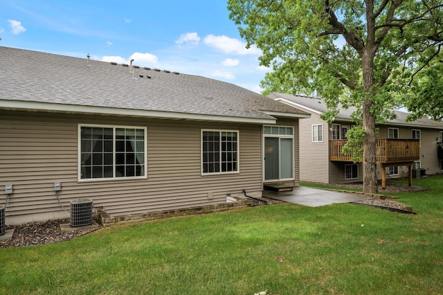 19136 Concord Ct NW, Elk River, MN 55330 - back of property featuring central AC unit, a yard, a shingled roof, and a wooden deck