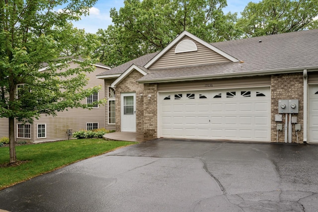 19136 Concord Ct NW, Elk River, MN 55330 - view of front of home with a shingled roof, brick siding, and asphalt driveway