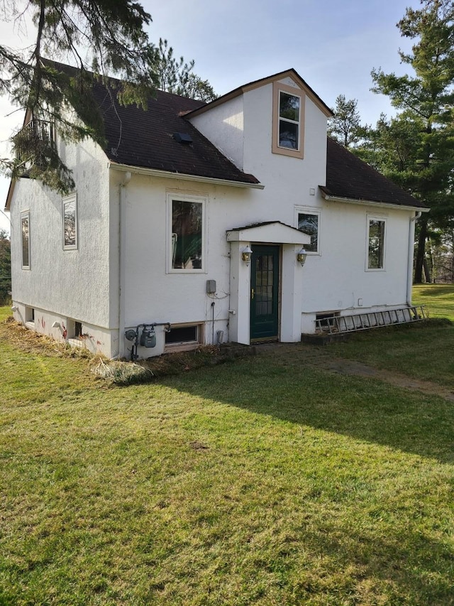 103 4th St, Grand Rapids, MN 55744 - view of front facade featuring a front yard, roof with shingles, and stucco siding
