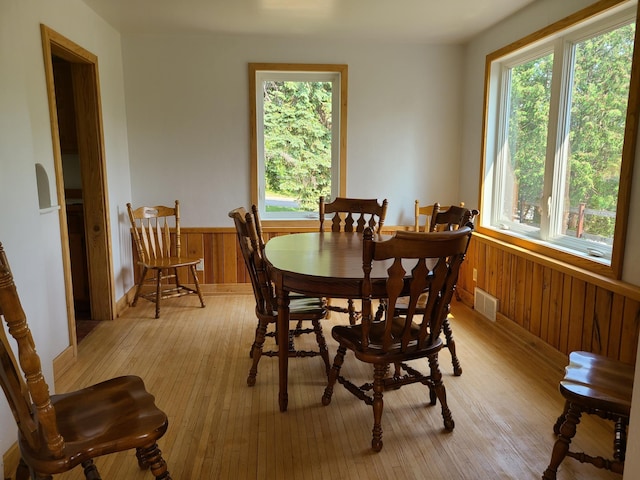 103 4th St, Grand Rapids, MN 55744 - dining area with wainscoting, light wood-type flooring, and wood walls