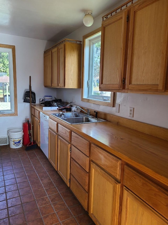 103 4th St, Grand Rapids, MN 55744 - kitchen with a sink, white dishwasher, and brown cabinetry