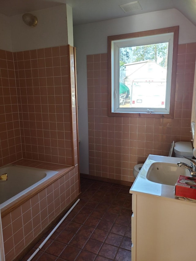 103 4th St, Grand Rapids, MN 55744 - full bathroom with toilet, vanity, tile walls, tile patterned flooring, and tiled shower / bath