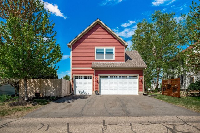 1013 Planters Path, Bayport, MN 55003 - view of front of home with fence, driveway, roof with shingles, and a garage