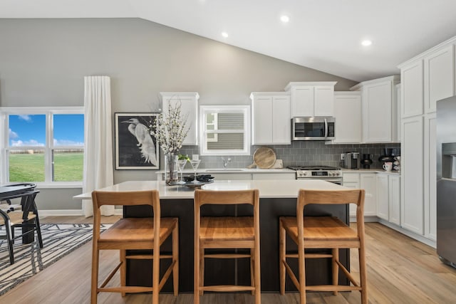 1951 Fulton Rd, Carver, MN 55315 - kitchen with appliances with stainless steel finishes, a sink, light countertops, a kitchen island, and backsplash