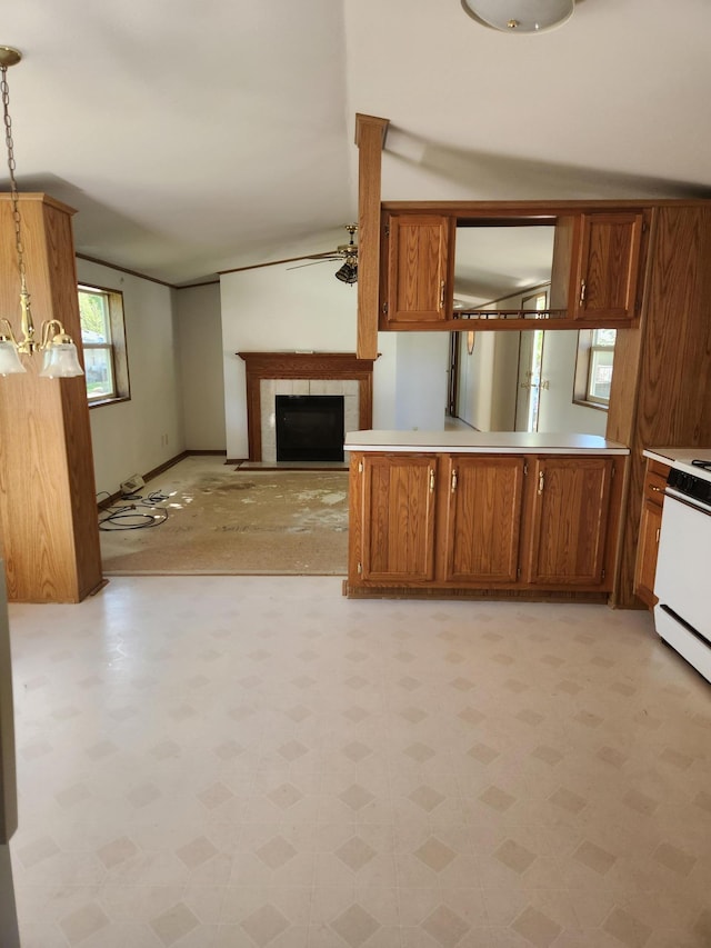 102 Jaybee Ln, Mankato, MN 56001 - kitchen featuring brown cabinetry, a fireplace, white range, pendant lighting, and light countertops