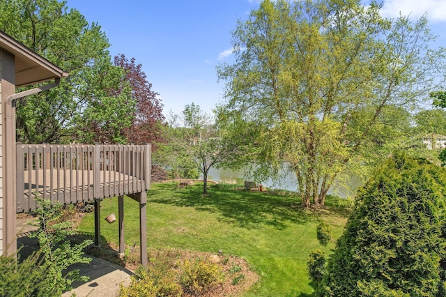 view of green lawn featuring a wooden deck