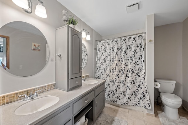 bathroom featuring toilet, double vanity, tile patterned floors, and curtained shower