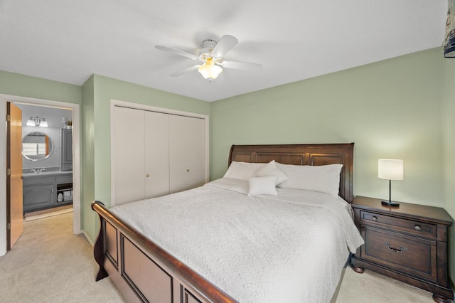 bedroom featuring light colored carpet, a closet, and a ceiling fan