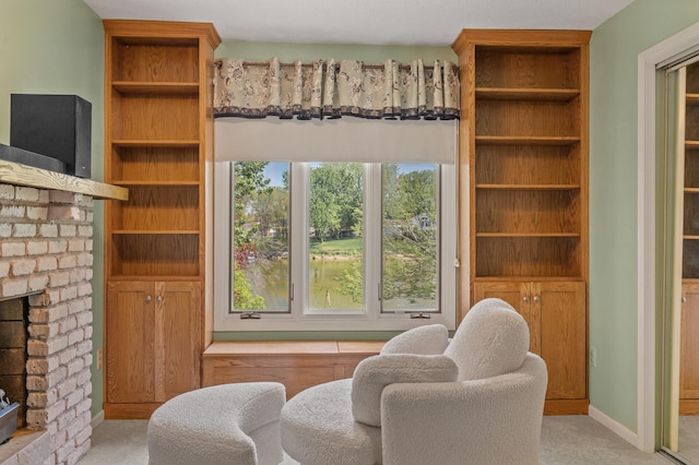 sitting room with a brick fireplace and carpet floors