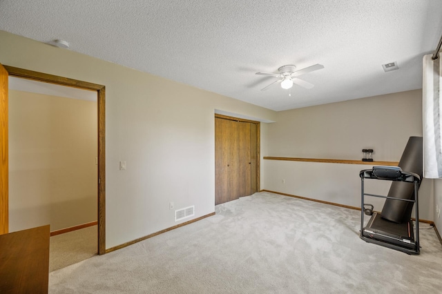 unfurnished bedroom with carpet floors, a closet, baseboards, ceiling fan, and a textured ceiling