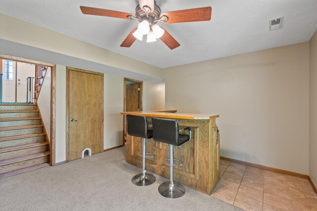 indoor dry bar with stairway, baseboards, and ceiling fan