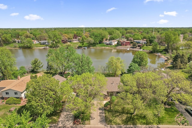 drone / aerial view of a nearby body of water and a forest
