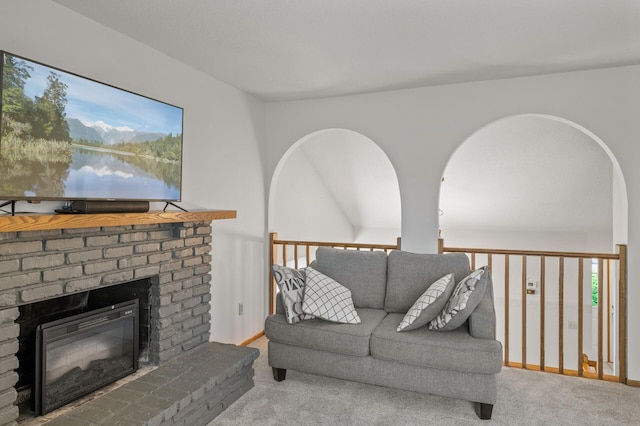 living area featuring carpet and a brick fireplace
