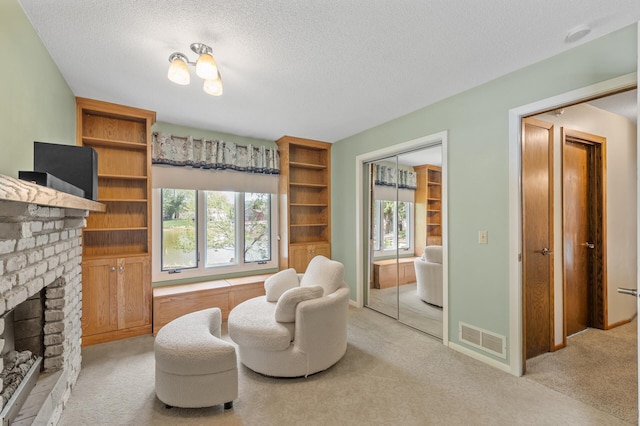 living area with plenty of natural light, light colored carpet, a brick fireplace, and a textured ceiling