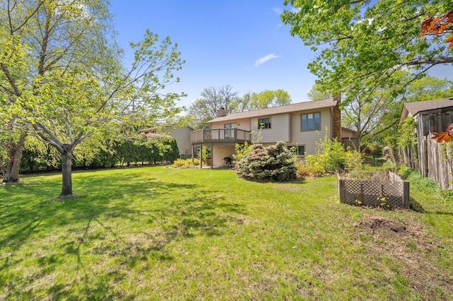view of green lawn with a wooden deck