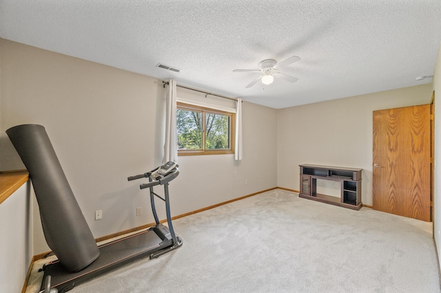 workout area with ceiling fan, carpet, a textured ceiling, and baseboards