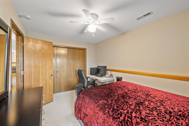 bedroom with a textured ceiling, a closet, a desk, and ceiling fan