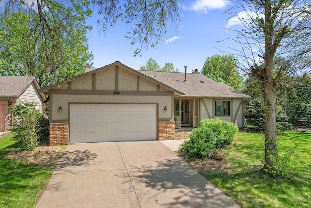 view of front facade with brick siding, an attached garage, concrete driveway, stucco siding, and a front yard