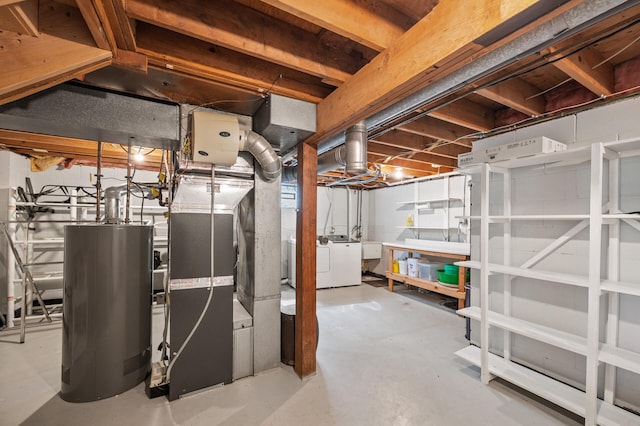 unfinished basement with water heater, independent washer and dryer, and heating unit