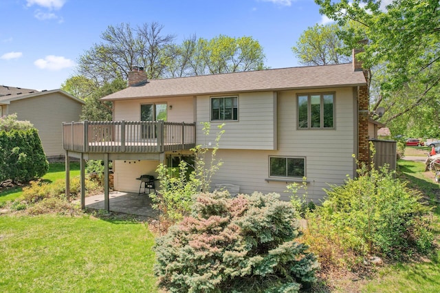 back of property featuring a chimney, a yard, a deck, and a patio area