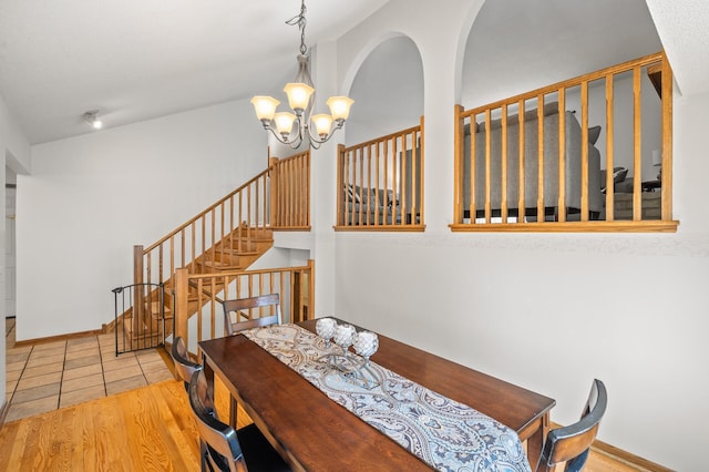 dining room featuring a chandelier, stairway, and tile patterned floors
