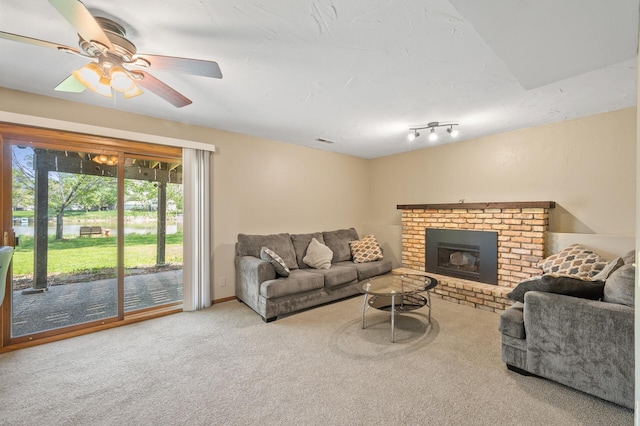 carpeted living room with a ceiling fan and a brick fireplace