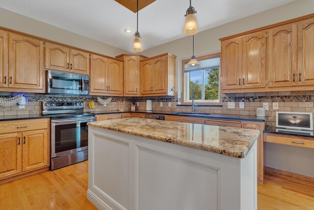 1502 9th St N, Sartell, MN 56377 - kitchen with appliances with stainless steel finishes, a sink, light wood-style floors, light stone counters, and backsplash