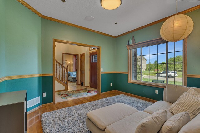 1502 9th St N, Sartell, MN 56377 - living area with stairs, crown molding, wood finished floors, and baseboards