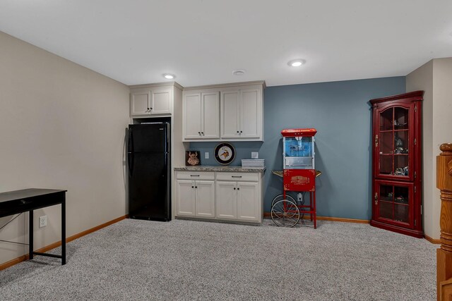 1502 9th St N, Sartell, MN 56377 - kitchen featuring freestanding refrigerator, light colored carpet, baseboards, white cabinets, and light stone counters