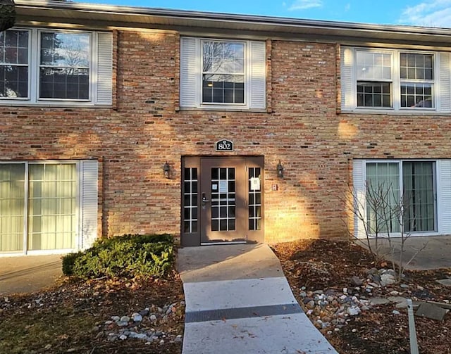 view of exterior entry with brick siding