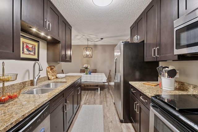 215 Barry Ave S Unit 306, Wayzata, MN 55391 - kitchen featuring appliances with stainless steel finishes, a sink, dark brown cabinets, light wood-style flooring, and a textured ceiling