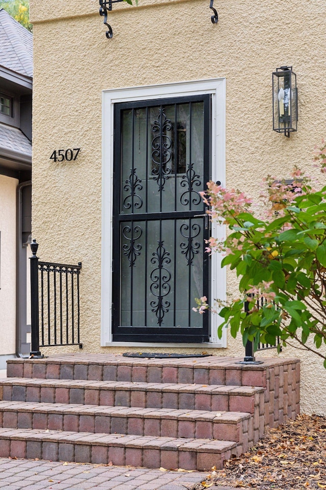 entrance to property featuring stucco siding