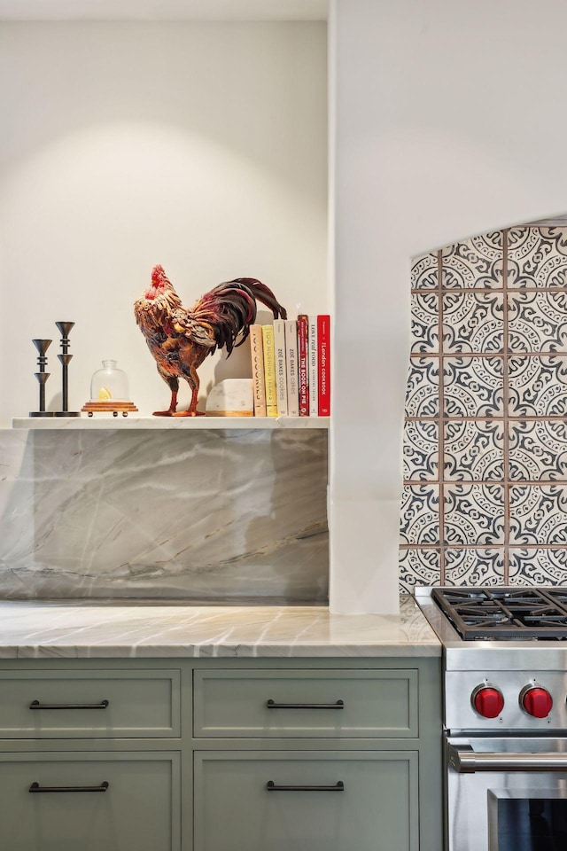 kitchen view of stainless steel stove, green cabinetry, and light countertops