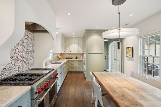 kitchen featuring double oven range, a sink, light countertops, recessed lighting, and dark wood finished floors