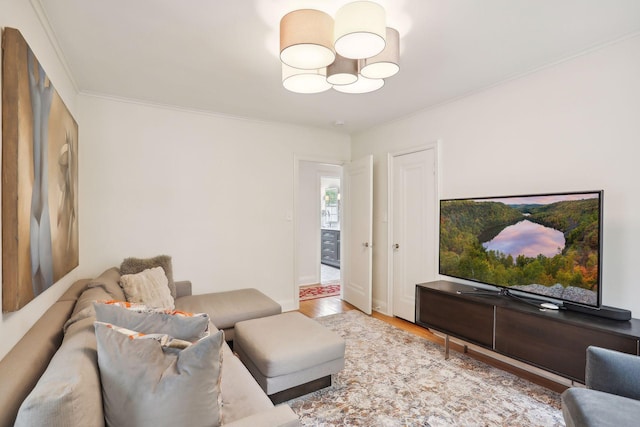 living room featuring wood finished floors, crown molding, and a chandelier