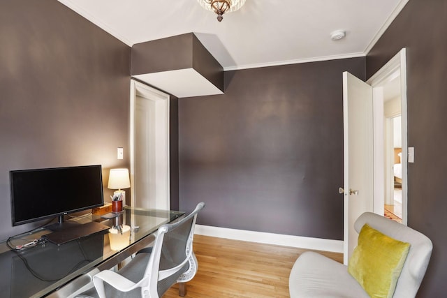 office space featuring wood finished floors, crown molding, and baseboards