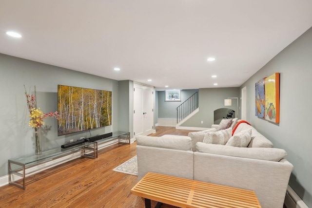 living area with wood finished floors, recessed lighting, stairway, and baseboards