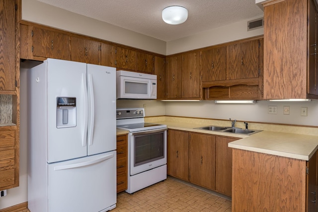 529 Spring St Unit 4, Kenyon, MN 55946 - kitchen featuring white appliances, a sink, light countertops, brown cabinetry, and a textured ceiling